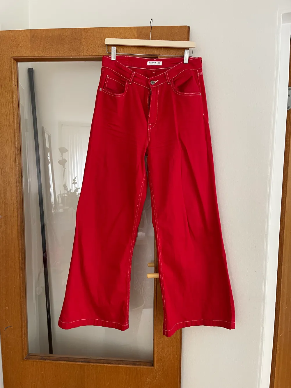 Sett från Pull&Bear, croppad jeans jacka och högmidjade utsvängda byxor. I en poppig röd kulör❤️. Jeans & Byxor.