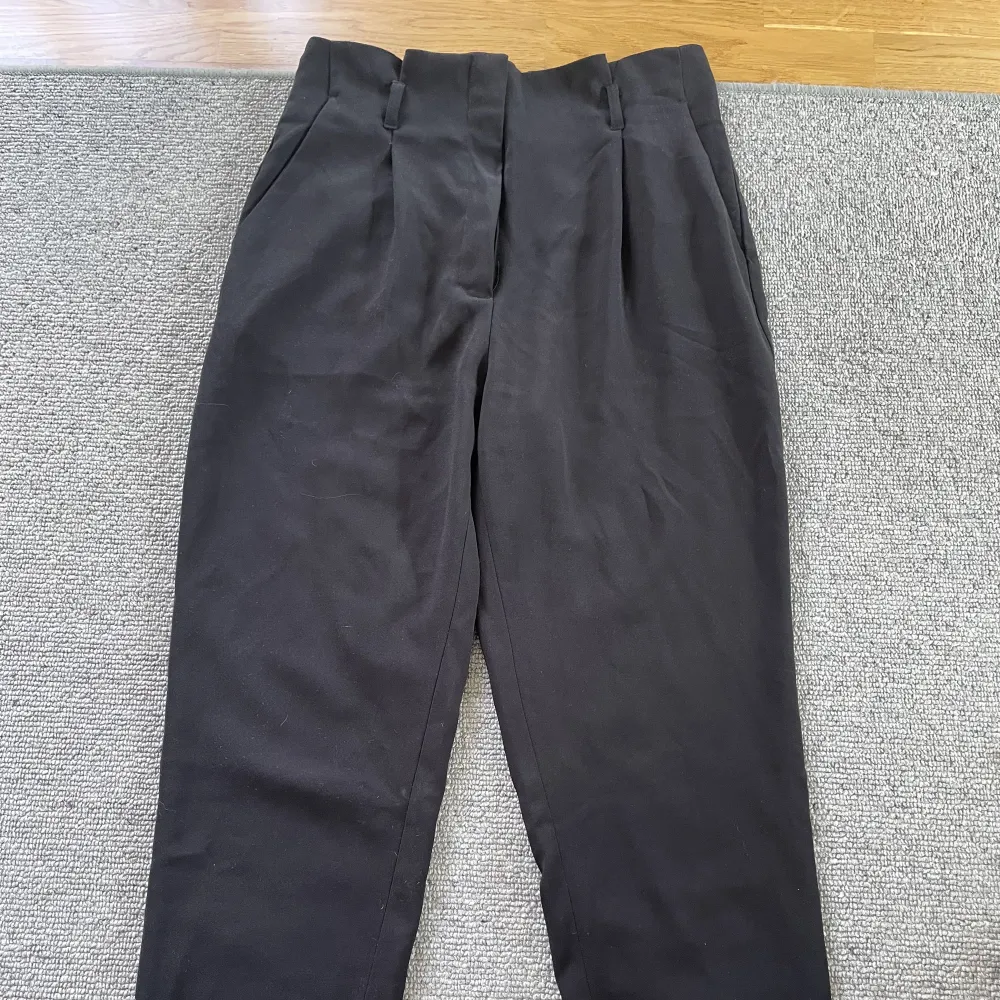 Svarta kostymbyxor med fickor både fram och bak. Jeans & Byxor.