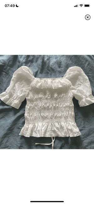 Vit top - Helt ny aldrig använd. Funkar som en off shoulder tröja och som vanlig tröja.  Hör av vid intresse eller för bilder av hur den ser ut på! 