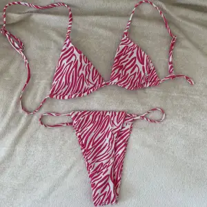 En rosa mönstrad bikini som aldrig kommit till användning (endast provad). Stringbikini som sitter super snyggt bak samt att den inte knyts  upp i nacken. 