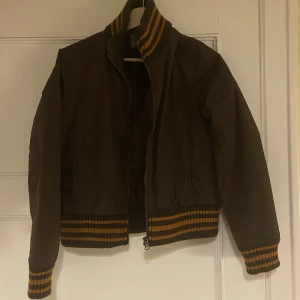 FETSNYGG HÖSTJACKA - Vindtålig! Varm men inte för varm men eftersom den stöter bort vind så funkar den galant på hösten/senhösten/tillåtes vintern. Kort så passar perfeeeeekt till ett par jeans.Håller den kärt, köpt på myrorna gbg. Därav priset, för jag älskar den, heheheh.