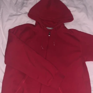 röd zip hoodie - klarröd zip hoodie köpt på secondhand för ett tag sen, jättemysigt material och fin färg! säljer för de inte riktigt är min stil längre, färgen i verkligheten är mest lik bild 2 och jag skulle säga att den inte är oversized i passform men den sitter löst.