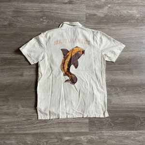 Nudie Jeans skjorta - En nudie jeans skjorta i typ grön-beige färg. Ger lite gröna toner men är beige. Nytvättad, därav skrynklig 😭. Sista bilden stretcha jag ut tröjan för att immetera en strykt och slät tröja. Mått:  Längd 65-68cm. Armhåla till armhåla 52.5cm. 