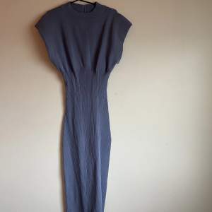 Fin klänning från Ginatricot, fin gråblå färg.  Korsettliknande i midjan. Storlek M, vadderade axlar. 