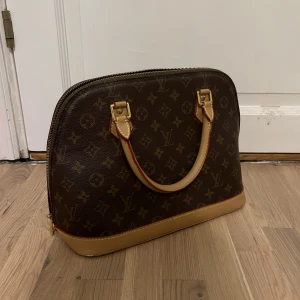 Louis Vuitton väska - Jättefin väska ifrån Louis Vuitton i modellen Alma. Väskan är köpt vintage och det finns därför inget äkthetsbevis mer än en kod inuti väskan. Den är i väldigt fint skick och endast använd vid några få tillfällen. Kan tänkas gå ner i pris! Lägg gärna bud!