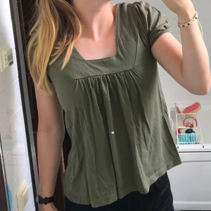 MILITÄRGRÖN T-SHIRT - Supersöt militärgrön t-shirt med cool urringning och söta ärmar. Köparen står för frakten💚