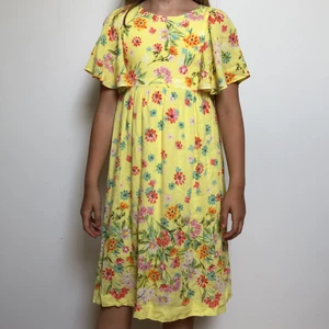 Gul och blommig klänning - Väldigt somrig klänning med blommor och ett litet hål på baksidan (dekoration). Cirka 4 år gammal och har sällan används. 