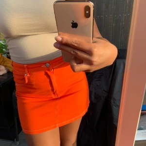 Orange kjol - Säljer en fin orange kjol från Bershka som knappt är använd. Den är ganska kort med vita sömmar. Frakt på 44kr tillkommer🦀