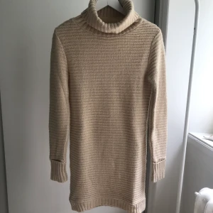 Stickad klänning - Beige stickad klänning med polokrage. Storlek 34 men passar även 36. Använd 1-2ggr. Nypris 500kr