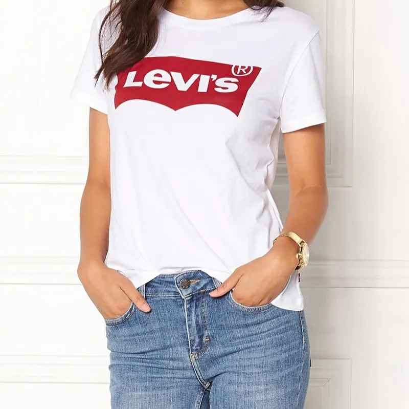 Klassisk t-shirt i bomull från Levi's. T-shirten har märkts logga tryckt framtill samt en rundad halsringning. Längd från axel bak 63 cm, byst 88 cm i stl. S. Modellen är 175 cm och bär stl. S. Maskintvätt 30 grader. Oöppnar. T-shirts.