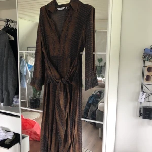 & Other Stories klänning - Super fin klänning från & Other Stories. Ormmöster och knyte i midjan. Använd 1 gång så super fint skick. Storlek 34 men passar även 36. Vid intresse kan jag skicka fler bilder.