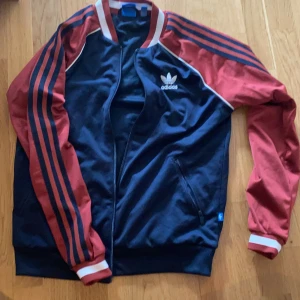 Adidas retro jacka/tröja i bombermodell - Kom med bud! Liten i storleken. Vinröd/marinblå. Bjuder på frakten.