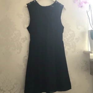 Klänning   - En oanvänd klänning som har spets detaljer, från H&M i storlek 36. Har dragkedja på ryggen och även ett tunnare material vid ryggen men är inte genomskinlig vid underdelen. 