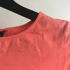 Cropp topp - Korallfärgad croppad t-shirt med tajt passform. Köptes för ca 130kr och säljes för 45kr.