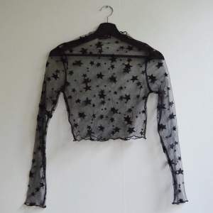 En långärmat tröja i mesh men svarta stjärnor på ifrån Zaful. Snarlikt identisk med Linn Ahlborgs fast med längre ärmar. Kanterna av halsringningen och ärmarna är lite fint detaljerade av lite vågigt material. Aldrig använd. Frakt 22kr