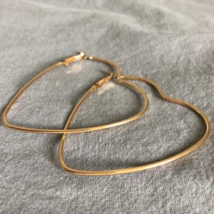 Guldiga hjärtörhängen - Guldiga hjärtörhängen, helt nya! Köparen står för frakten (11kr). Har ni några frågor är det bara att höra av sig! :)