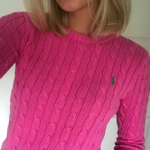 Kabelstickad tröja från Ralph Lauren. Ceriserosa färg med grönt märke. Tillverkad i 100 % bomull. Använt mycket sparsamt, så i jättefint och bra skick. Fraktavgiften står köparen för💓 Storlek: xsmall men mer som en small.  Nypris: 1300 kr