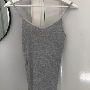 SpetsLinne  - Säljer ett linne från Hm. Färgen är ljusgrå och har spets upptill. Frakt tillkommer. (Färgen är ljusare än på bilden) slut överallt. Skriv för mer detaljer