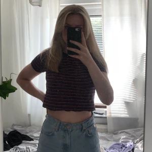 Brandy melville crop top - Säljer den söta röd, blå och vit randiga crop toppen från Brandy melville. Måttligt använd men fortfarande i väldigt bra skick. Fraktkostnad tillkommer :)