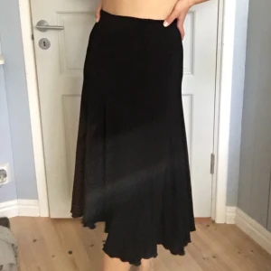 Svart midikjol - Svart stretchiga midikjol med volangsöm. Frakt tillkommer på 45kr<3