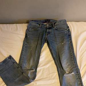 Ett par ljus blå Tommy Hilfiger jeans i storlek 32 i denton modellen. Jeansen har rak passform med öppningar runt knäna. Kan mötas i Stockholm annars står köpare för frakt. Inköpspris 1200