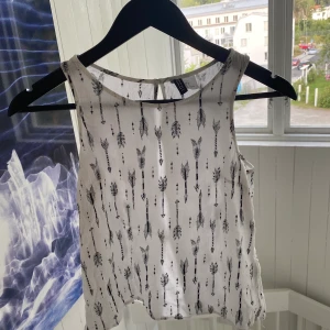 Linne med detaljer i ryggen! - Supersnyggt vitt linne med mönster. Väldigt fina detaljer i ryggen. Säljs nu för att det är för litet för mig tyvärr!