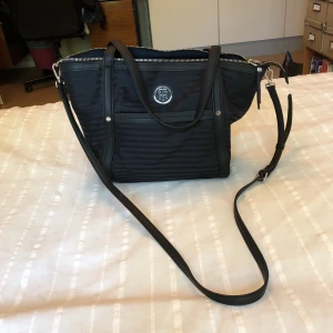  - Snygg och stilren Tommy Hilfiger väska. Mått: 28x40x11 cm. Oanvänd och i mycket gott skick!  Nypris: 1200kr. 