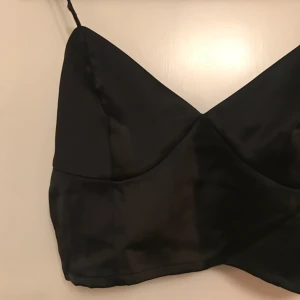  - Partytopp i svart siden, passar 36-40 beroende på hur stora bröst man har. Perfect skick. *Frakt ingår i priset👍🏼*