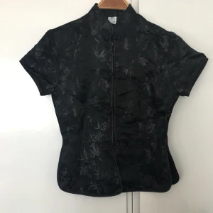  - Svart siden blus traditionell kinesisk med ståkrage och fina sydda knappor. Strl s nyskick.