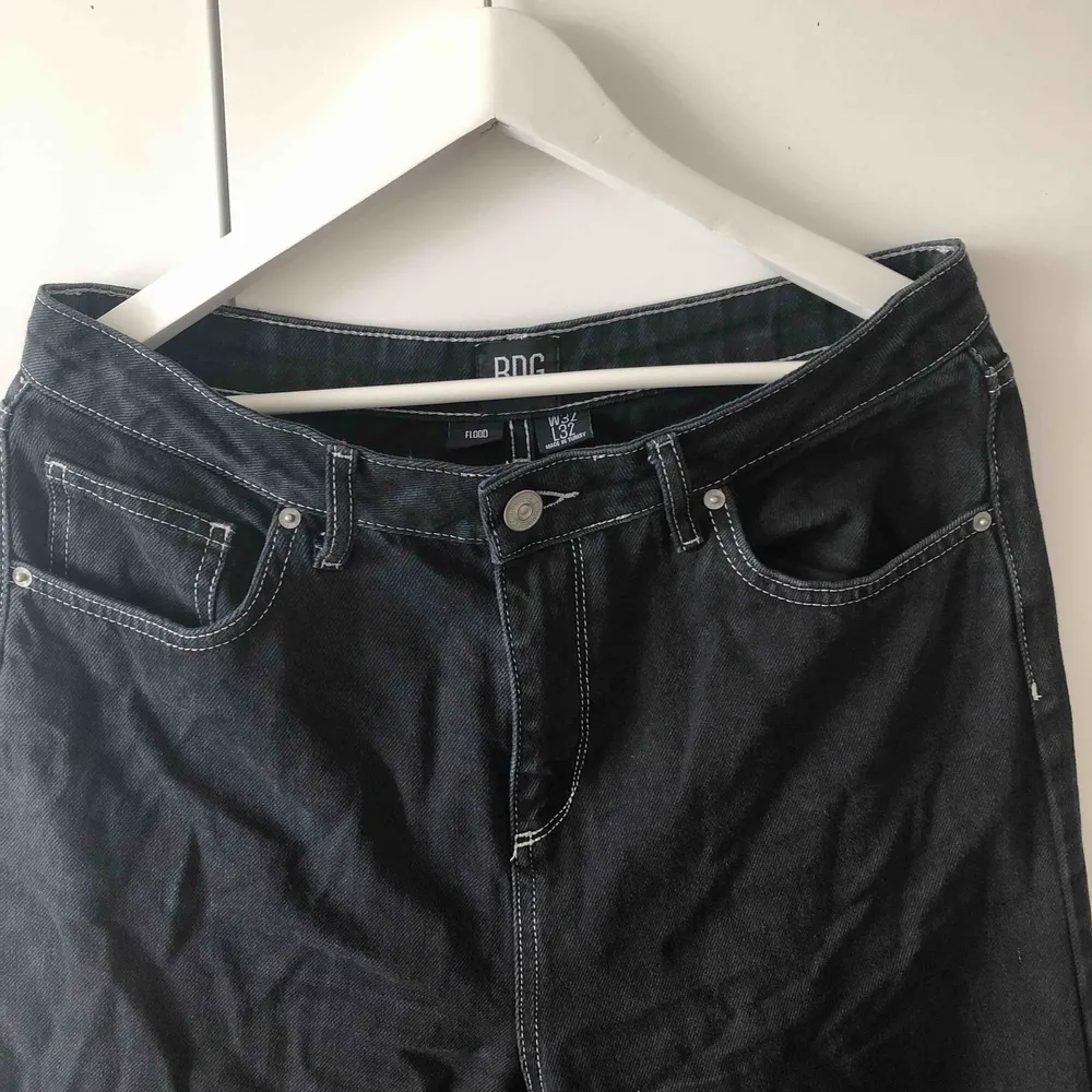 Mått- W32 L32. Snygga svarta utsvängda jeans med vita sömmar från Urban Outfitters. Korta i längden. . Jeans & Byxor.