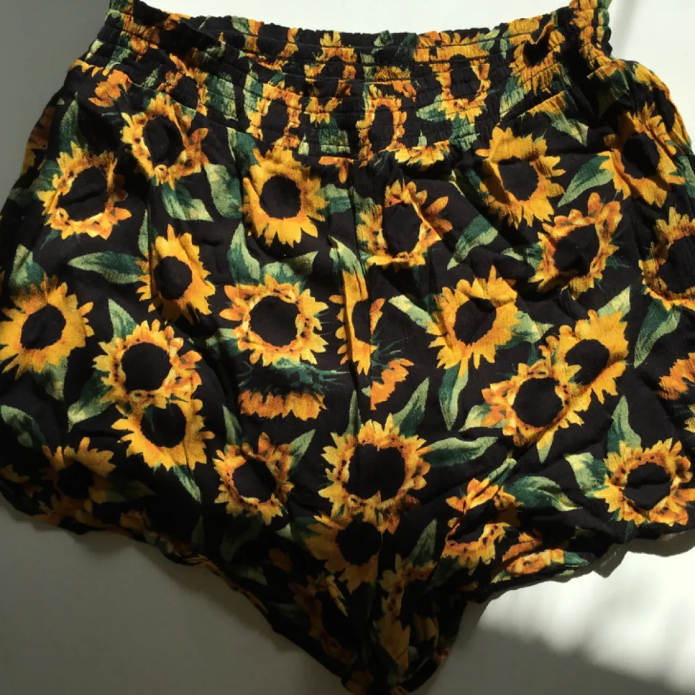 Superfina somriga shorts från monki med härliga solrosor på! Sällan använda så i fint skick!  Frakt tillkommer . Shorts.
