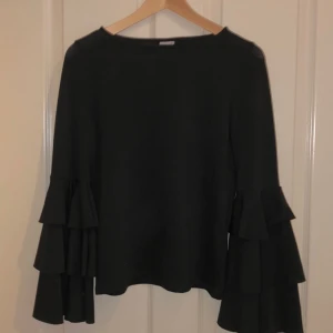  - Svart tröja med volangärmar, i mycket gott skick. Använd ungefär 3 gånger🌟 