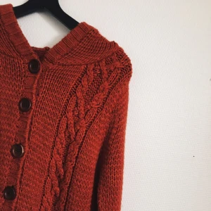  - Roströd stickad kofta med luva från H&M. Jättemysig men kommer tyvärr inte till användning. Lite längre i modellen. Bilderna gör inte färgen rättvisa, den är lite mattare röd.  Frakt tillkommer!