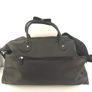  - Weekend väska. 
Svart, läderimitation. Litet fack utanpå och inuti. Reglerbart axelband. 