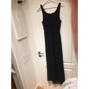  - Svart långklänning från Gina Tricot. Storlek 36, passar mer en storlek 38. Rund öppning i rygg och slits på båda sidor av klänningen upp till knähöjd.