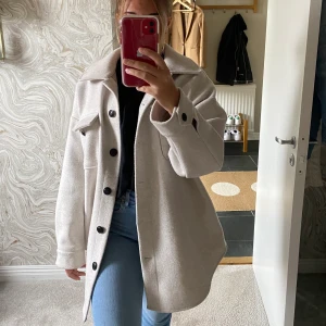 oversized jacka från Nelly - Oversized jacka från Nelly i storlek 34. Jackan är vit/ ljusbeige och det medföljer ett skärp. Ganska väl använd men ändå ganska bra skick. Nypris 699, mitt pris 250
