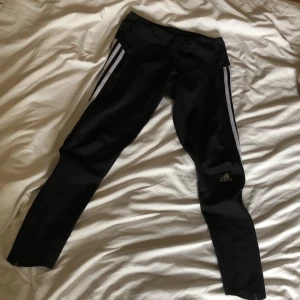 Träningstights adidas - Träningstights i funktionsmatrerial från adidas. Lärfter modell men sparsamt använda. Haft dom i flera år men har länge varit för små. Strl s. Har dragkedja på båda benenlpngst mer samt en ficka uppe på högra höften. Medelhöga i midjan, välsett sköna och stretchiga. Andningsmaterial runt höfterna och dragkedjorna på benen går upp till knäna. 