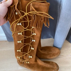 Minnetonka Minnetonkas stl 37! Jättefint skick på skorna  - Säljer ett par höga fina Minnetonkas i stl 37! Knappt använda så skulle säga att dom är i nyskick! Djur och rökfritt hem! Bor man i Uppsala kan jag mötas upp här annars skickar jag dom med postnord skicka lätt 63:- (då kan man följa paketet) 