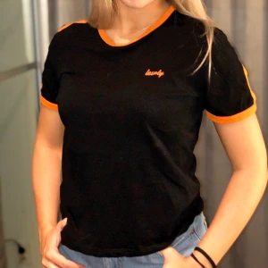 NA-KD T-shirt - En svart T-shirt med snygga oranga detaljer från NA-KD. Kom med ett bra pris. Frakt tillkommer