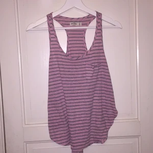  - Ett linne ifrån Abercrombie kids i storlek 16 (vilket motsvarar ca XS/S). Linnet har en ficka på ena bröstet, brottarrygg och slits på sidan. 