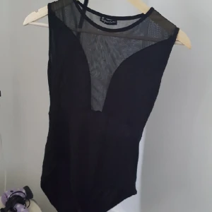  - Svart body med transperanta detaljer. Frakt på 30 kr tillkommer🌼