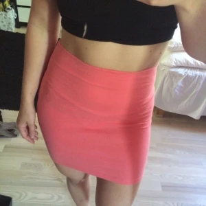  - Stretchig korallfärgad kjol med hög midja.