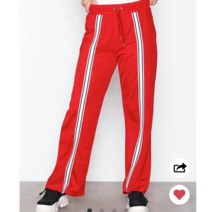 Vida röda byxor med stripes - Vida byxor ”Sweet WCT Panel” med knytband och svartvita ränder som detaljer på framsidorna. Finns en strl XS och tre strl S