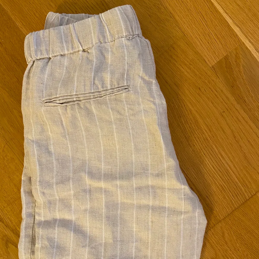 Säljer dessa beigea linne byxor med vita ränder från Mango. Bra kvalitet och så snygga till sommaren! Är 167 och brukar ha 34/36 i byxor och dessa sitter bra förutom att de är en aning för korta. Jeans & Byxor.