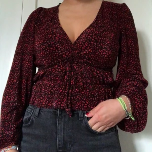 Zara blus röd/svart strl S - Jättefin blus från zara. Svart med mörkröda prickar sitter jättefint, vringad och slutsåld. Org pris 300 tror jag använd fåtal gånger. Jätteskönt tunt material.