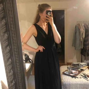  - Svart lång ballklänning, använd en gång. Så den är i riktigt bra skick! Inköpspris från MQ 1499kr. Saknas en liten knapp där uppe men där är en till som håller det uppe fint! Skickar gärna fler bilder/video i bättre ljus! Frakten står köparen för :)