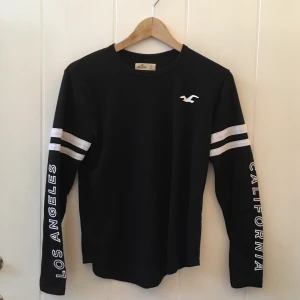 Hollister-tröja - Svart tröja med vita detaljer, superskön!    Står att det är storlek XS men sitter bra på mig som har M
