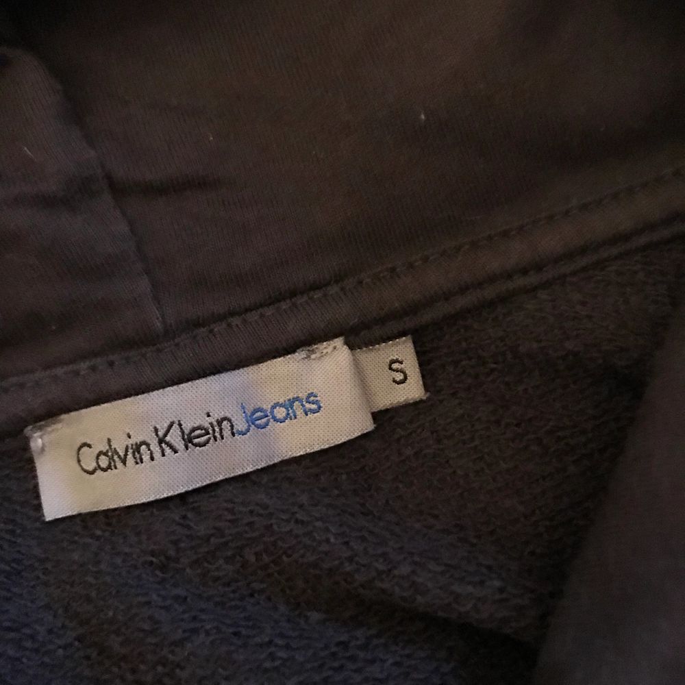 Calvin Klein hoodie i en gråsvart färg (se andra bilden). Storleken är S men tycker den sitter mer som en XS. Använd cirka 10 gånger men är hel och ren. Frakt tillkommer 📦. Huvtröjor & Träningströjor.
