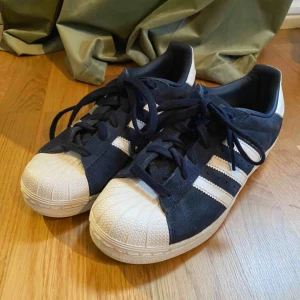  - Adidas superstar, blåa i mocka/läder material. Jättefina men typ aldrig använda!    Köparen står för frakten, kan mötas upp i norrtälje eller Stockholm. 