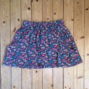  - Kjol i blommigt somrigt tyg med resår i midjan. Fickor på båda sidor och härligt svängig. 